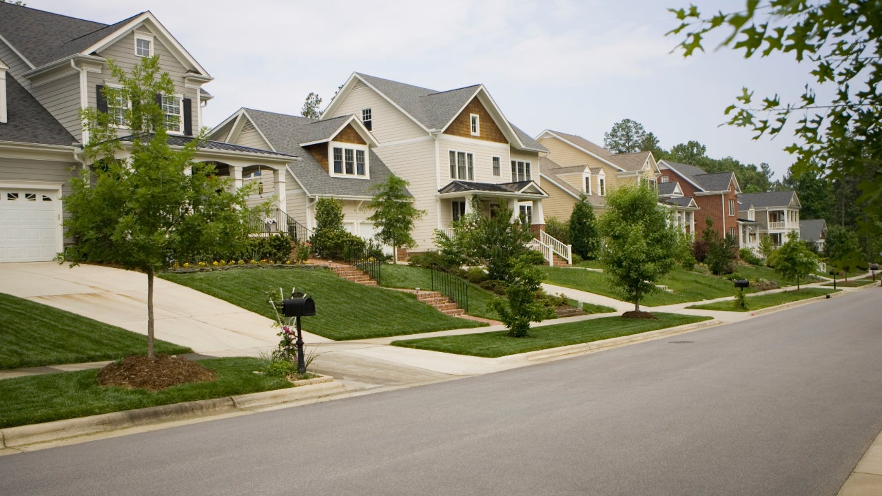 A well-maintained residential HOA community street with tidy homes and landscaping